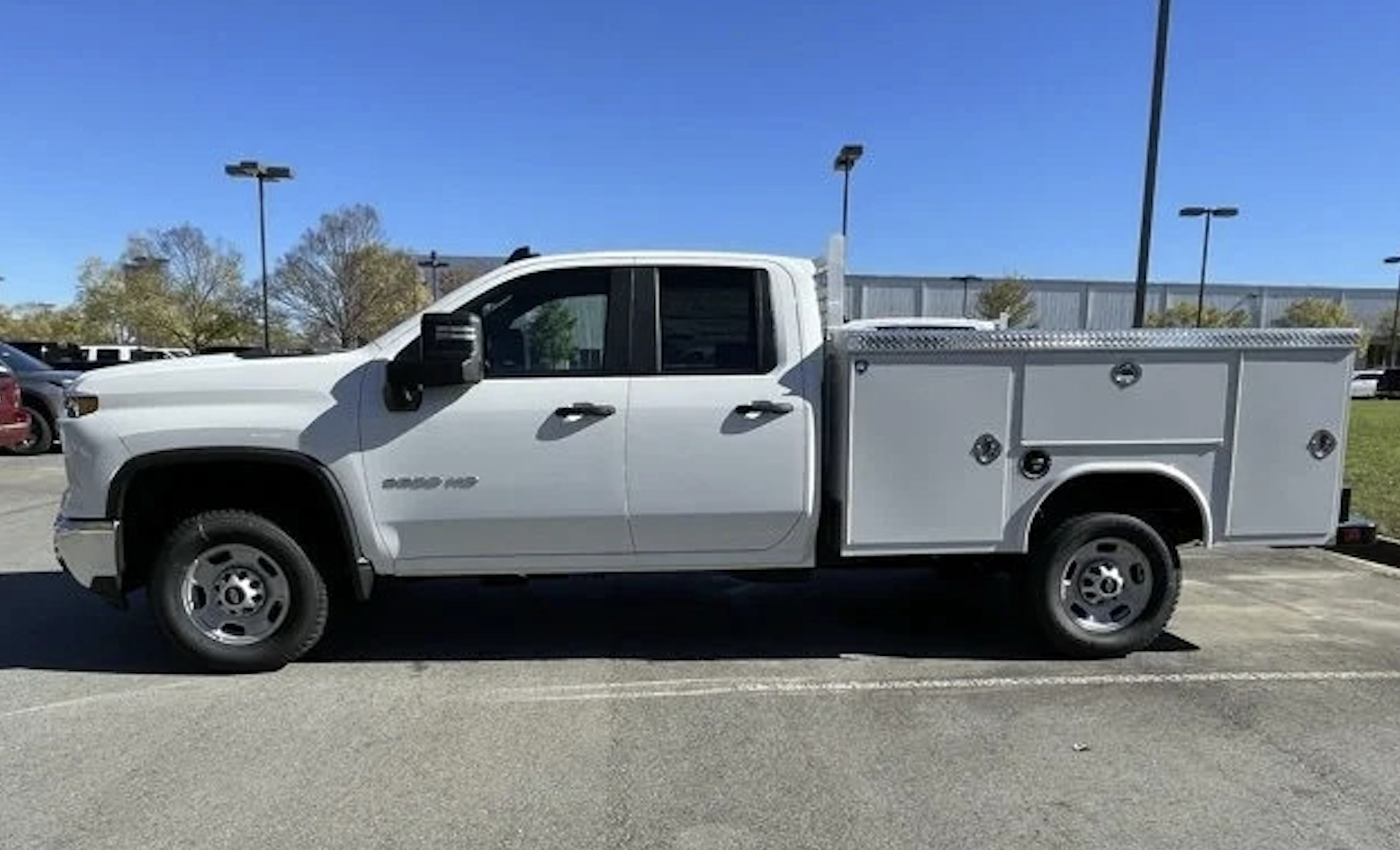 White Chevy Silverado 2500 HD with utility body parked at Crain Chevrolet in Little Rock, Arkansas